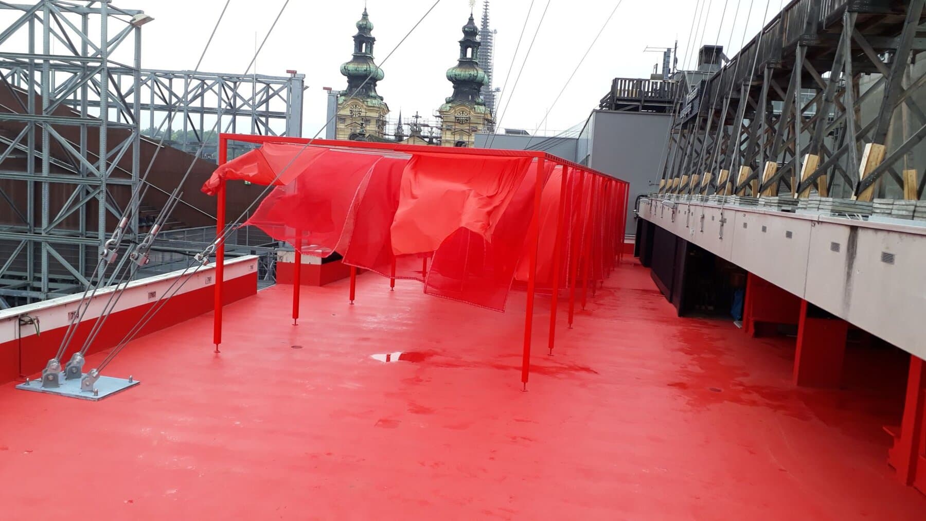 Rote Dachterrasse mit Stahlgerüst über der Linzer Altstadt